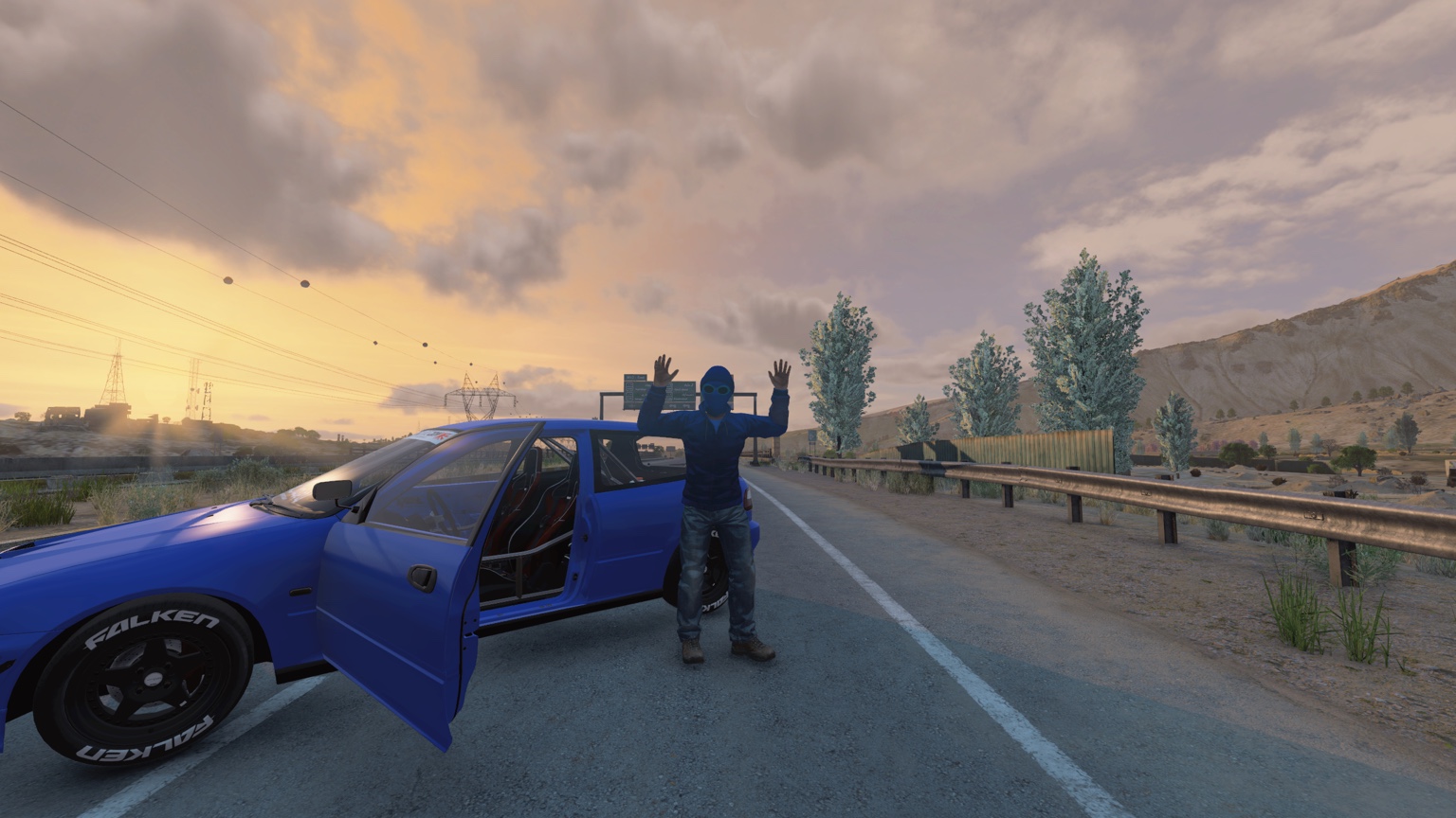 Survivors beside a blue car on a Badlands road at sunset